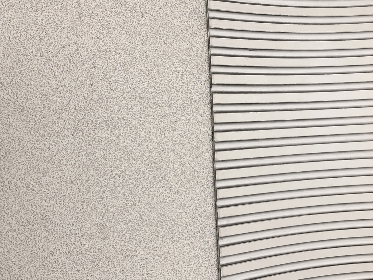 Close-up of a textured light gray surface next to a white ribbed or slotted material, showing material/color options.