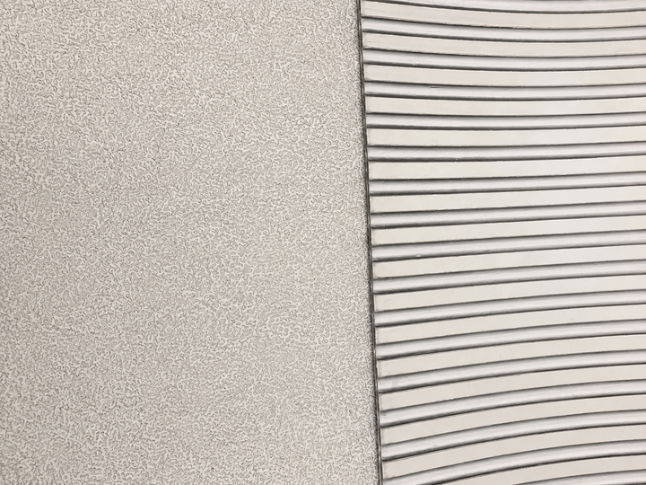 Close-up of a textured light gray surface next to a white ribbed or slotted material, showing material/color options.
