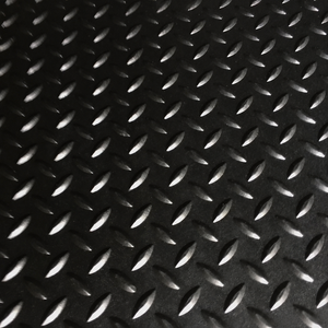 Black diamond plate textured mat with raised metallic-looking raised patterns on a dark background.