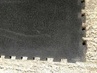 Close-up of a textured black surface with a stone wall border