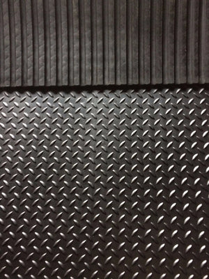 Close-up of a textured black rubber mat with diamond plate pattern
