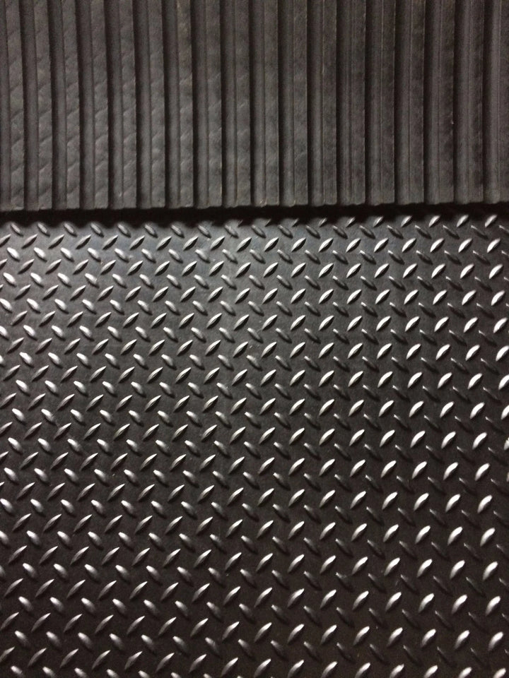 Close-up of a textured black rubber mat with diamond plate pattern