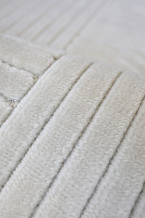 Close-up of a cream-colored textured fabric with vertical ribbed stripes.