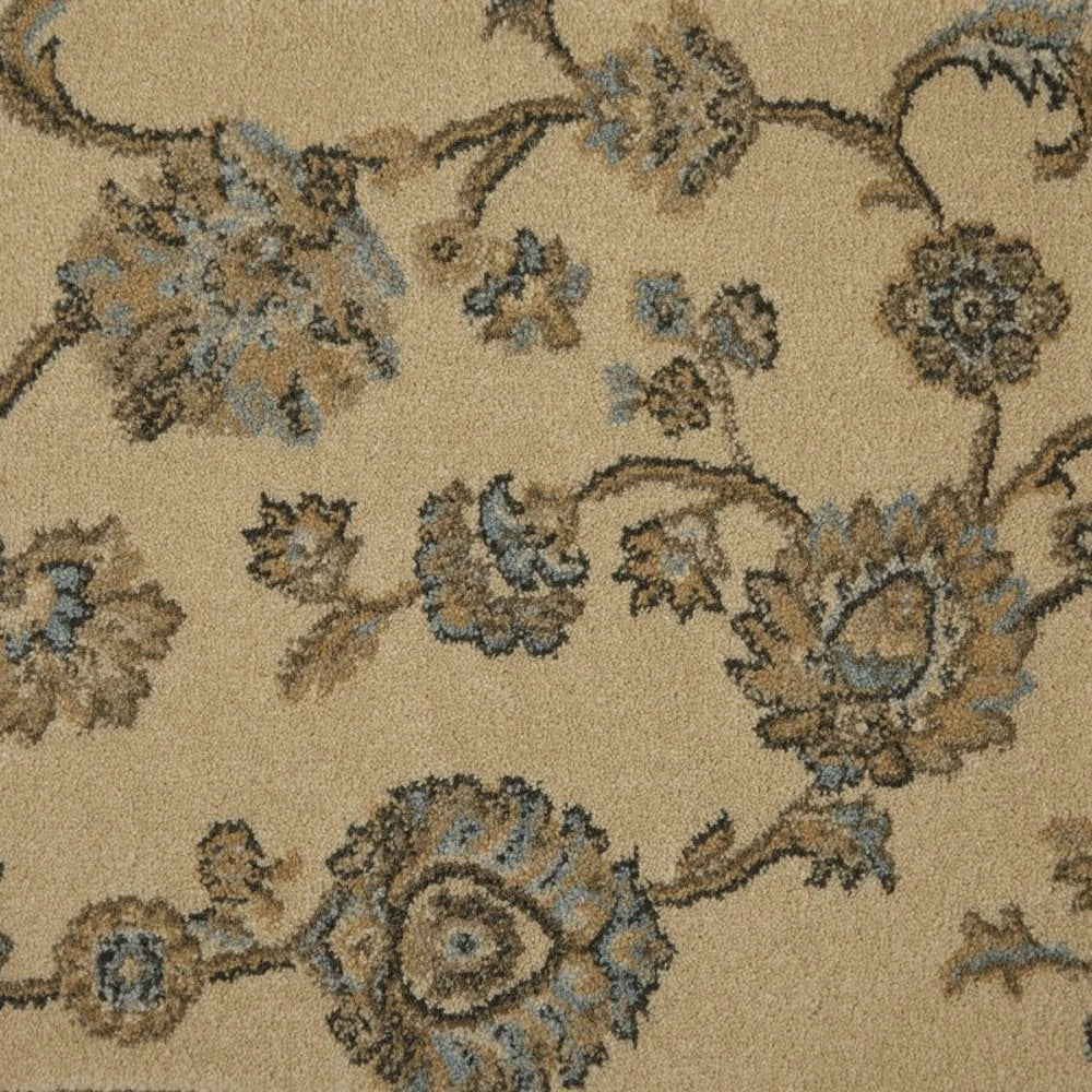 A close-up of a beige area rug with a traditional floral pattern in shades of brown, tan, and light blue.