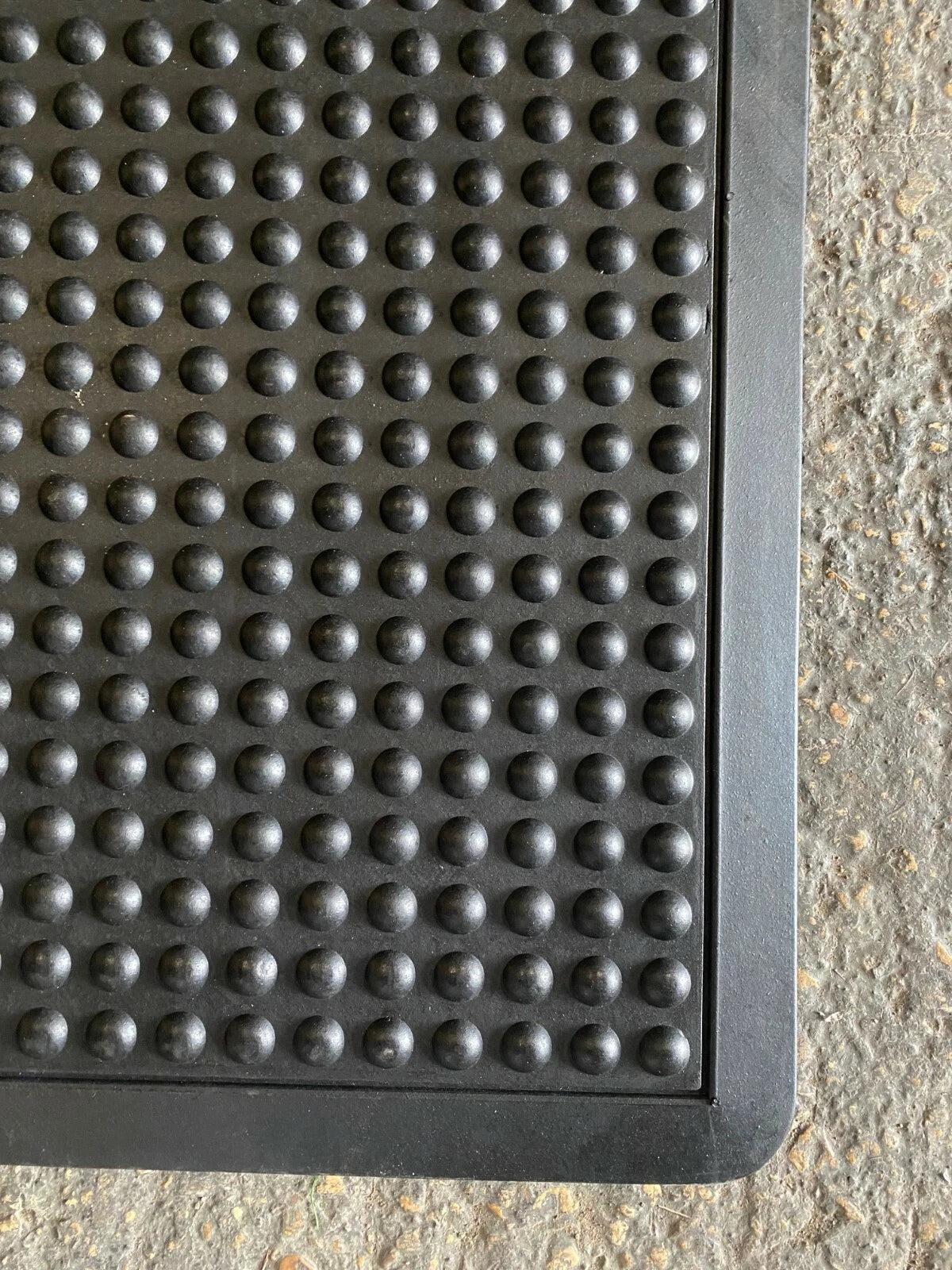 Textured black mat on a concrete floor
