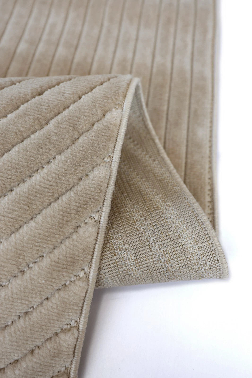 Close-up of a textured beige fabric with a diamond pattern on a white background