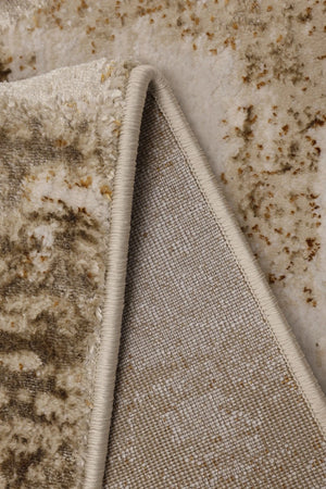 Close-up of a beige and cream textured rug with a distressed pattern, showing the pile from one side and the woven backing from the other.