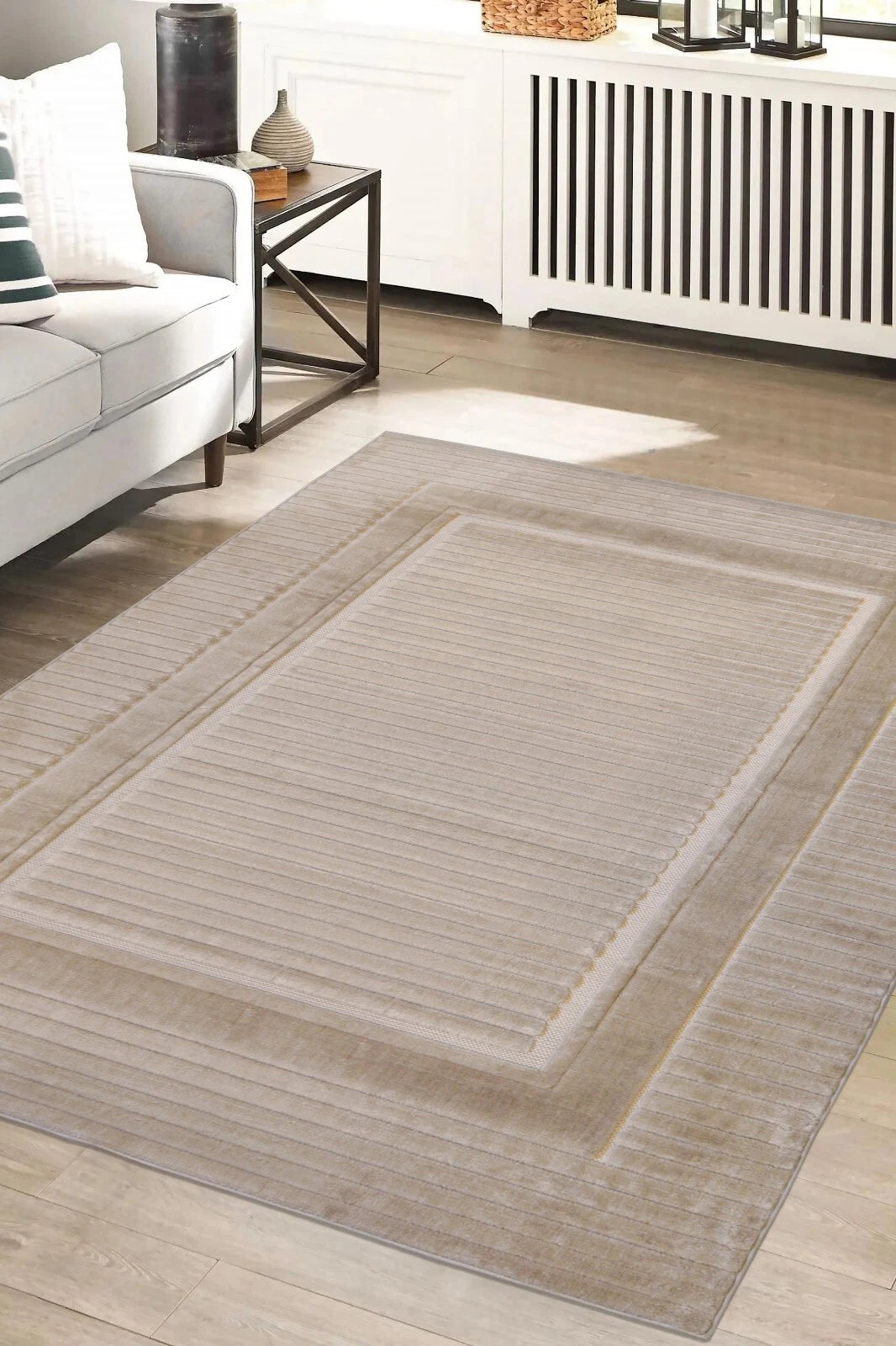 Gray area rug on a wooden floor in a living room setting.