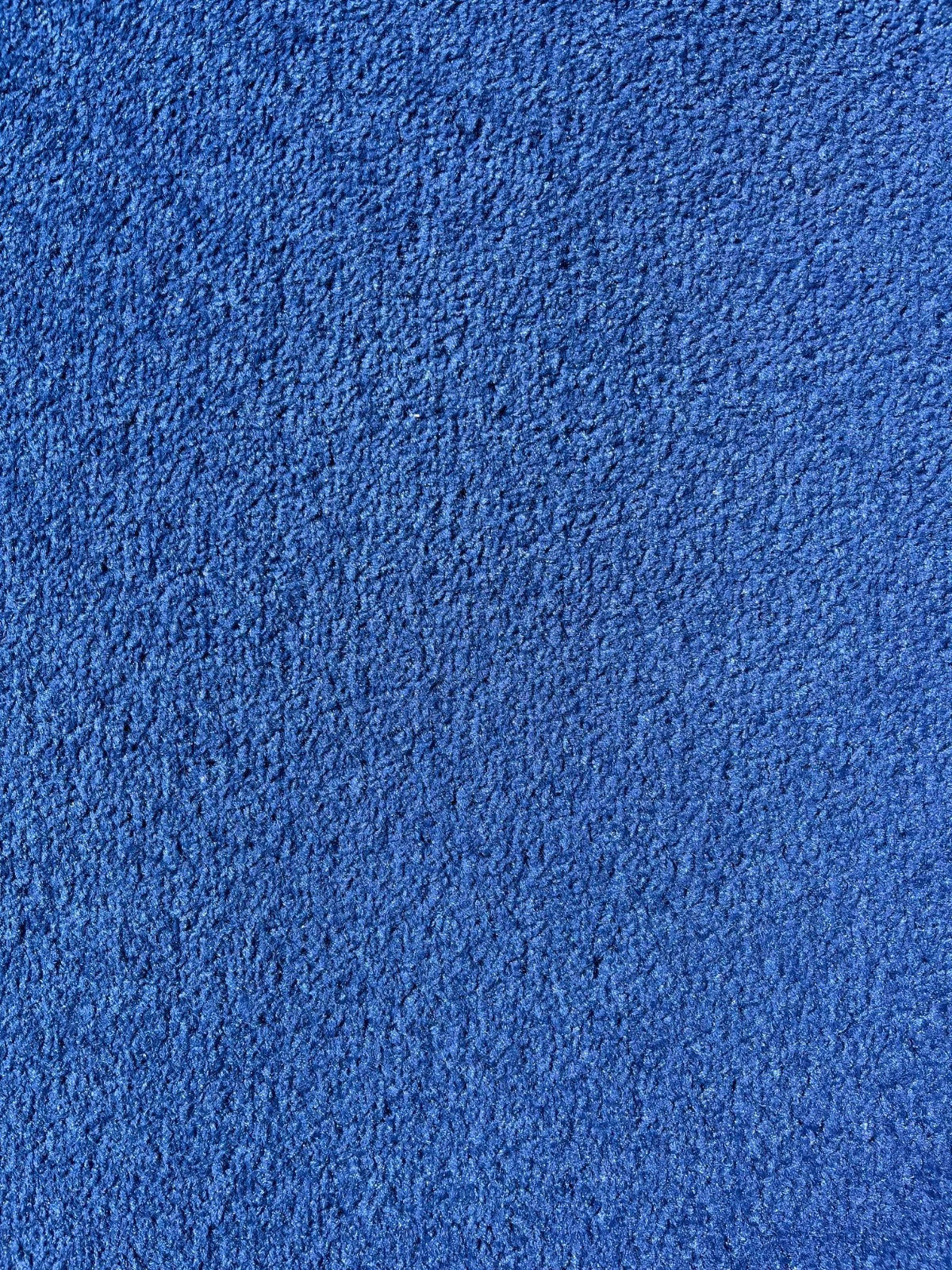A close-up texture shot of a vibrant blue plush fabric, showing the soft, looped pile detail.