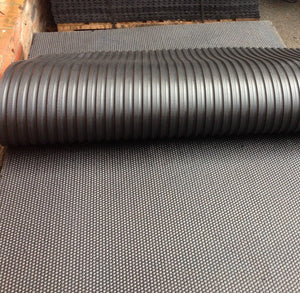 Roll of black corrugated material on a textured surface