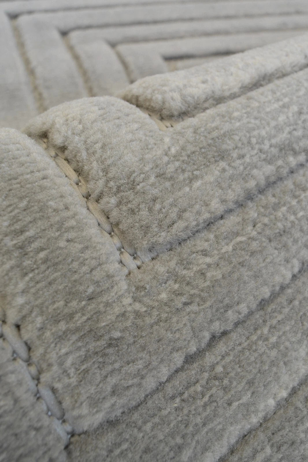 Close-up of a textured gray rug with geometric pattern