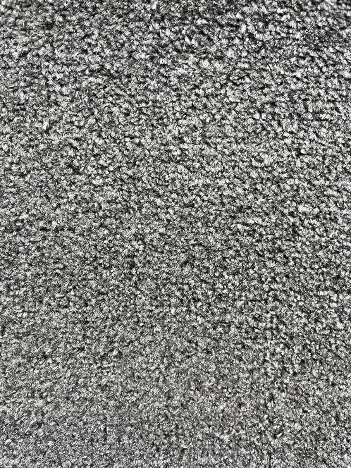 A close-up texture shot of a gray and white melange carpet or fabric, showing a dense, short-pile looped texture.