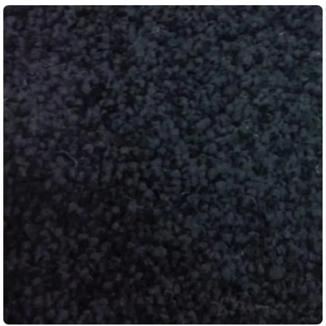 A close-up texture shot of a dark charcoal gray loop pile carpet, showing the dense, short fibers and subtle sheen.
