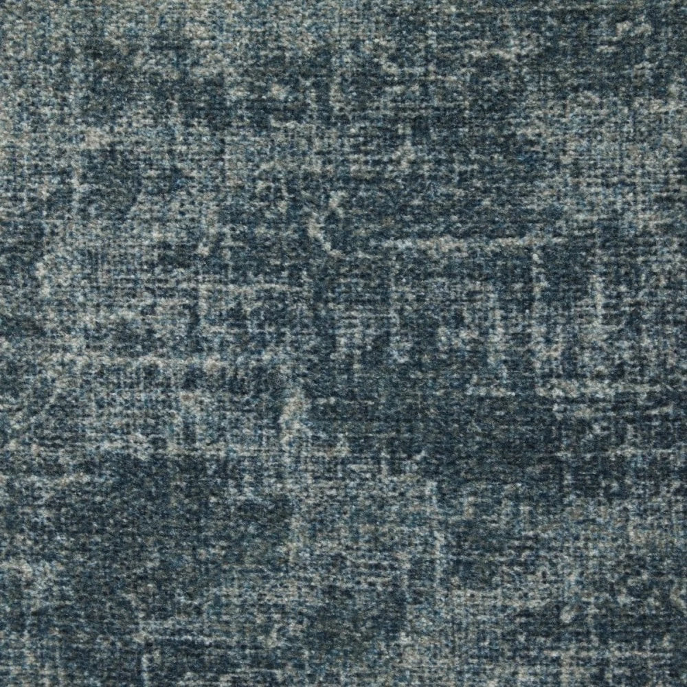 A close-up of a textured fabric or rug surface in a distressed blue-gray colorway with subtle tonal variation.