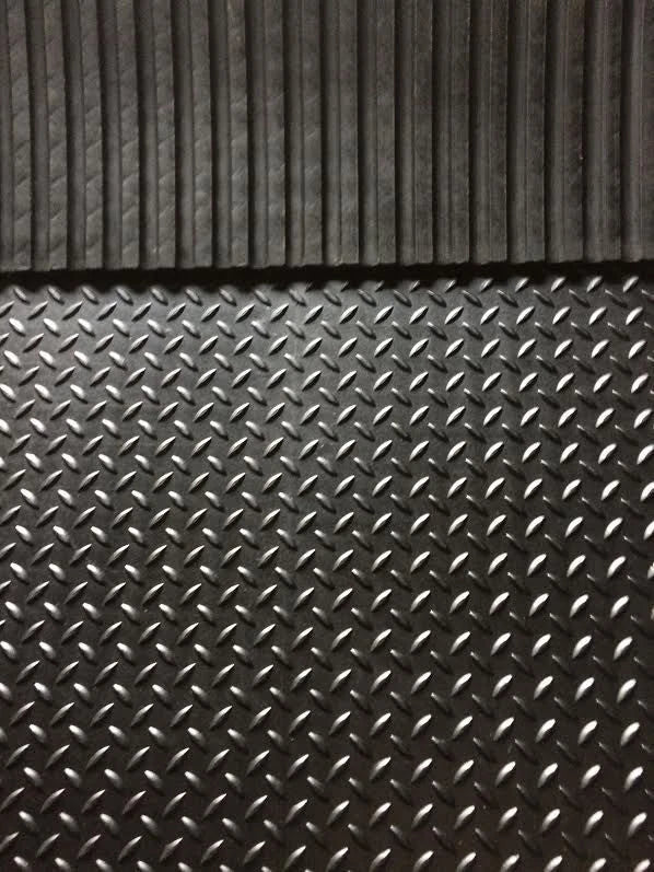 A close-up of a dark gray textured rubber or plastic mat with two distinct patterns: a ribbed vertical design at the top and a diamond plate pattern at the bottom.