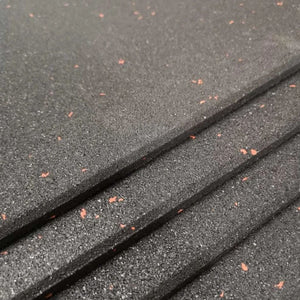 Angled close-up of stacked 10mm heavy duty fine crumb rubber gym floor tiles with burnt orange flecks.
