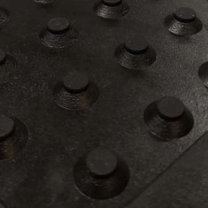 Close-up view of the heavy-duty conical rubber drainage studs on the underside of a horse stable mat.