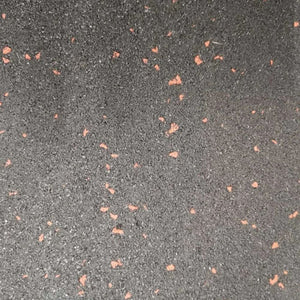 A flat top-down close-up of a black rubber gym floor tile featuring a slip-resistant textured surface with red EPDM flecks.