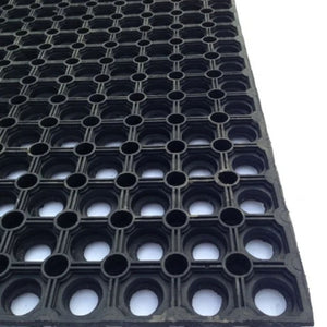 Black rubber mat with a grid pattern of circular holes, shown at an angle on a white background.