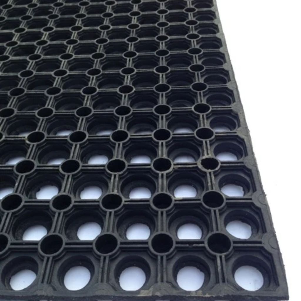 Black rubber mat with a grid pattern of circular holes, shown at an angle on a white background.