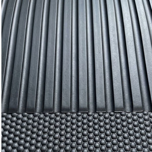 Close-up of a dark gray textured surface with vertical ridges on the upper portion and a raised honeycomb pattern across the lower portion.