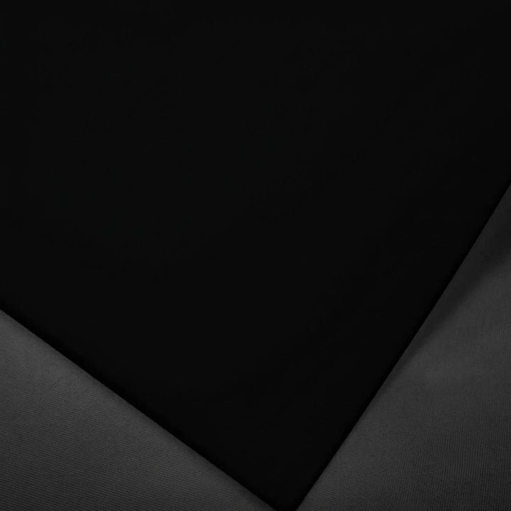 A close-up of a black textured material, likely leather or high-gloss fabric, folded to show its smooth surface and fine grain against a dark gray background.
