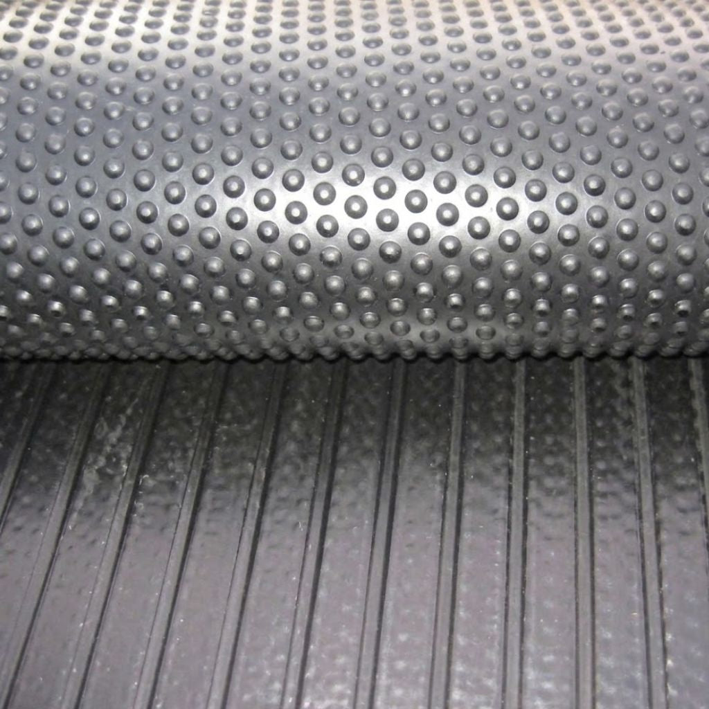 A close-up split view of an 18mm thick heavy-duty rubber stable mat, showing the raised bubbletop surface on top and deep linear drainage grooves on the underside.