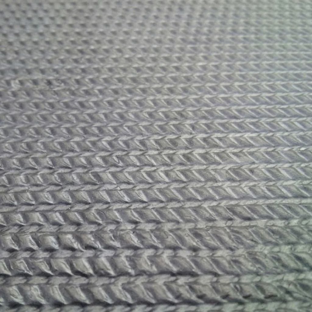 Close-up of a textured gray woven fabric with a repeating chevron or herringbone pattern.
