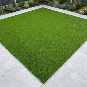 A neat square patch of 40mm fake lawn astro turf installed on a modern grey tiled patio.