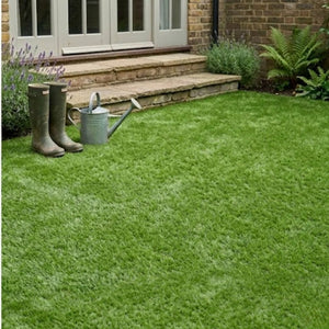 Realistic artificial grass laid out in a backyard garden lawn next to brick steps and boots.